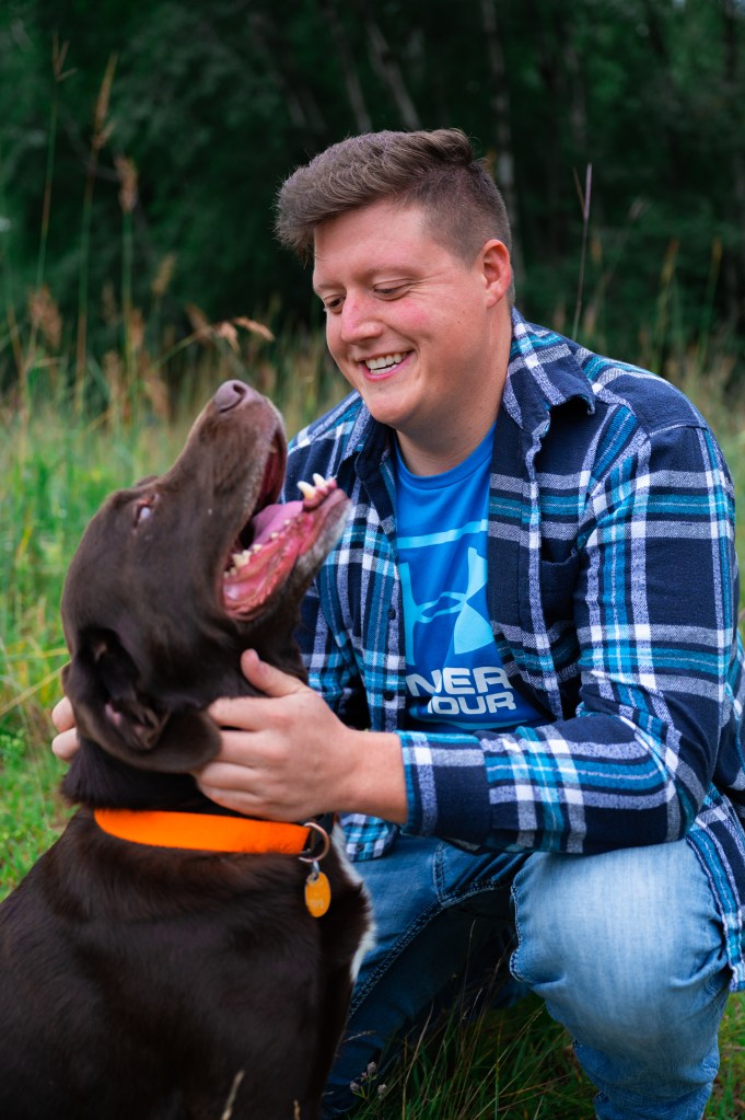 Close up of man in nice clothes poses for portrait with pet dog