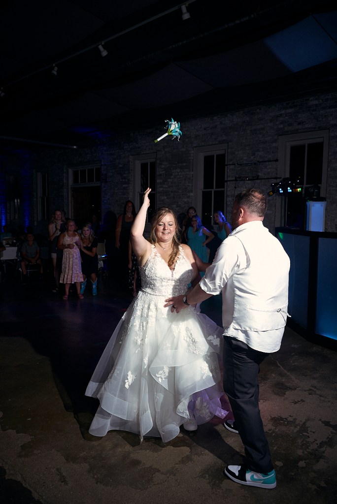 High contrast photo of Bride Throwing Bouquet to crowd