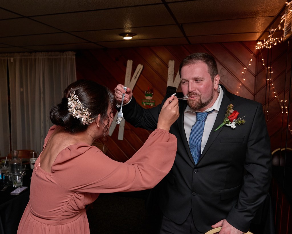 Weddig photo of Bride and Groom share a piece of cake with each other at wedding reception